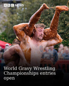 two men are wrestling shirtless in gravy.