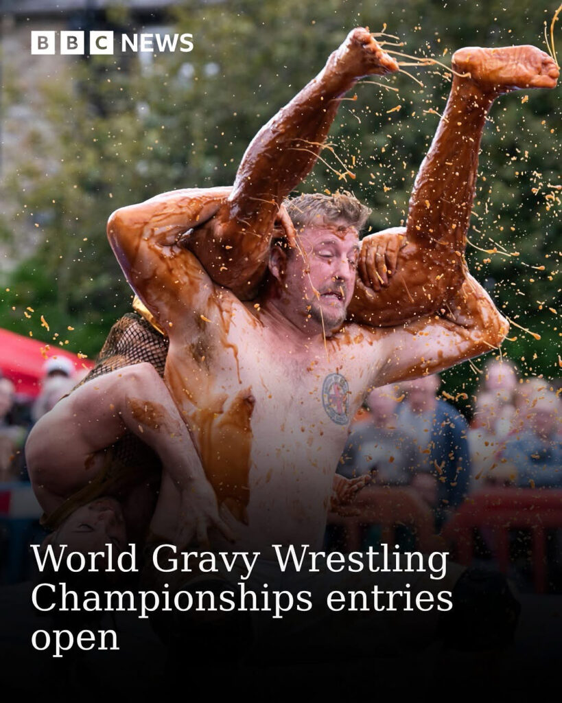 two men are wrestling shirtless in gravy.